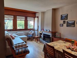 a living room with a couch and a table at Espot Natura - Apartament de muntanya al PN Aigüestortes i Sant Maurici in Espot