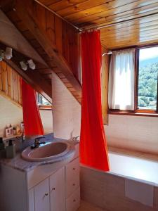 baño con lavabo y cortina roja en Espot Natura - Apartament de muntanya al PN Aigüestortes i Sant Maurici en Espot