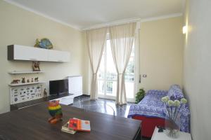 a living room with a table and a couch and a tv at Riviera Apartments in Levanto +25 photos