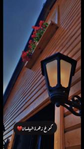 a black street light on the side of a building at كوخ البيلسان in Al Shafa