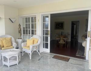 ein Wohnzimmer mit weißen Stühlen und einem Tisch in der Unterkunft Luxury apartment in villa in La Orotava