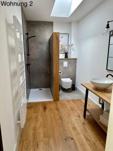 ein Bad mit einer Dusche, einem Waschbecken und einem WC in der Unterkunft Ferienwohnungen Tenner in Jüterbog