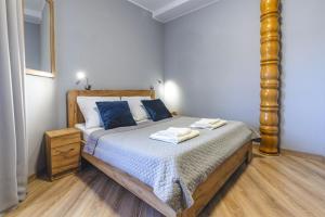 a bedroom with a large bed with blue pillows at Royal Gdansk in Gdańsk