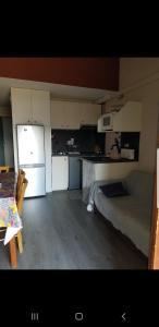 a kitchen with white cabinets and a couch in a room at Chalet, 5 couchages, wifi, garage, parking gratuit Les Fontanilles Draps et serviettes non fournis in Font-Romeu-Odeillo-Via