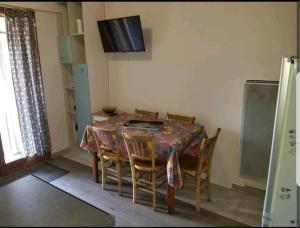 uma sala de jantar com uma mesa e cadeiras e uma televisão em Chalet, 5 couchages, wifi, garage, parking gratuit Les Fontanilles Draps et serviettes non fournis em Font Romeu Odeillo Via