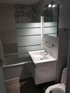 a bathroom with a sink and a toilet and a mirror at Chalet, 5 couchages, wifi, garage, parking gratuit Les Fontanilles Draps et serviettes non fournis in Font-Romeu-Odeillo-Via