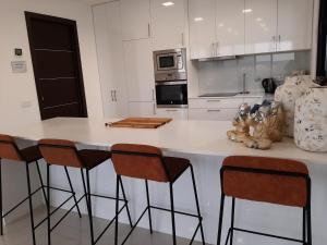 una cocina con encimera blanca con taburetes en Villa White Lagoon, 6 guests, 2 bathrooms, heated private pool, amazing view, fully Equiped ! en Alfeizerão