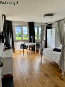 1 dormitorio con cama, escritorio y mesa en Ferienwohnungen Tenner, en Jüterbog