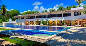 a swimming pool in front of a building at Oasi Encantada - Beach Resort in Santa Cruz de Barahona