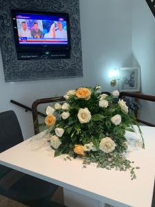 een witte tafel met een boeket bloemen erop bij Guesthouse Vladimir & Ana in Pančevo