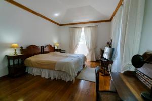 1 dormitorio con 1 cama y TV. en Monte Ingles, en Ponta Delgada