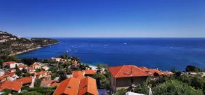 vista su una città con tetti rossi e sull'oceano di Vue magnifique, piscine privée chauffée et sauna à 10min de Monaco a Roquebrune-Cap-Martin