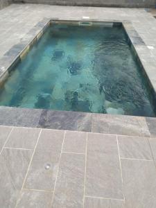 a pool of water on a patio with a tile floor at Le coin paisible in Saint-Louis