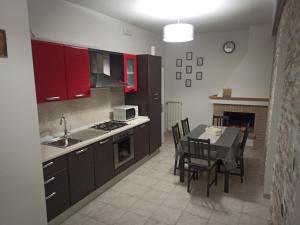 a kitchen with red cabinets and a table with chairs at B&B COLLE TARIGNI in Manoppello