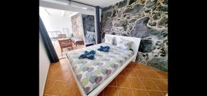a bedroom with a bed and a stone wall at villa del mar puerto del carmen in Puerto del Carmen