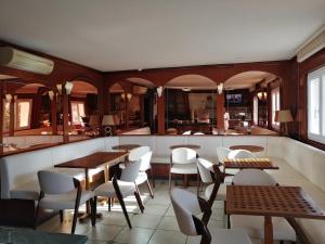 a restaurant with tables and chairs and a bar at Hôtel Le Claridge in Propriano