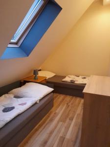 a attic bedroom with two beds and a blue ceiling at Apartamenty rodzinne U Zośki 1 in Łukęcin