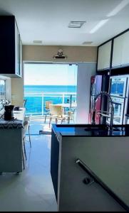 a kitchen with a view of the ocean from a balcony at Cobertura Duplex Vista Mar in Mangaratiba