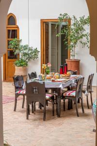 een eettafel en stoelen in een kamer met een tafel en een stoeltje bij Riad Dar Talah in Marrakesh
