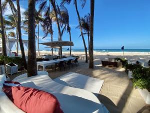 a patio with a table and chairs and the beach at Suíte ACONCHEGO no Villa do porto a 300m do Beach Park e a 5 minutos a pé da praia in Aquiraz