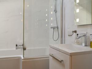 a white bathroom with a shower and a sink at King Offa Lodge - Uk10261 in Penrhôs