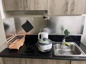 a kitchen counter with a sink and a mixer at Pasay Coast Residences JCMJ in Manila