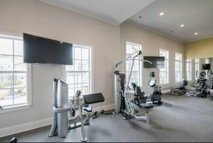 a gym with several treadmills and machines in a room at Luxury 2 Bedroom 2 Bath and 1 Car Garage with Pool in Memphis