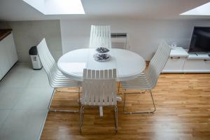 a white dining room table and chairs with a bowl on it at Apartman Mazić Nikšić in Nikšić