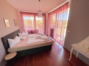 una camera da letto con un letto e una grande finestra di Seepark Velden a Velden am Wörthersee Altre 15 foto