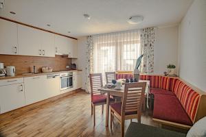 eine Küche und ein Wohnzimmer mit einem Tisch und Stühlen in der Unterkunft Apartments Renata Gries 201 in See