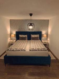 a bedroom with a blue bed with two night stands at Kod Dida in Gospić