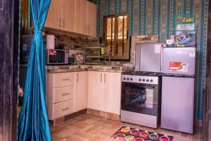 a kitchen with a refrigerator and a stove at Zahi Home, your cosy tiny home experience in Naro Moru
