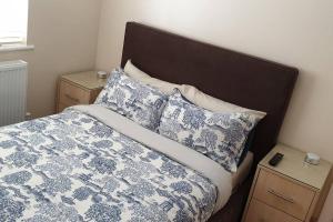 uma cama com lençóis e almofadas azuis e brancos em London Luxury Apartment 3 Bed 1 minute walk from Redbridge Stn Free Parking em Wanstead