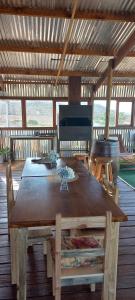 drewniany stół i krzesła w pokoju z grillem w obiekcie Windy Rose - Rustic Karoo Villa w mieście Barrydale