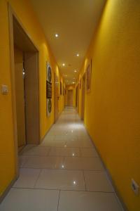 an empty hallway with yellow walls and a tile floor at Heidelberg Apartments in Heidelberg