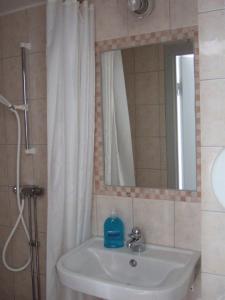 a bathroom with a sink and a shower with a mirror at Rönninge Gård in Rönninge
