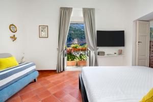 a hotel room with a bed and a television at The Positaner in Positano