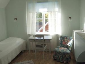 a bedroom with a bed and a table and a chair at Rönninge Gård in Rönninge