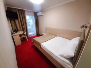 ein Hotelzimmer mit einem Bett und einem Schreibtisch in der Unterkunft Tourist Chernivtsi in Czernowitz