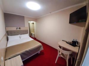 a hotel room with a bed and a desk at Tourist Chernivtsi in Chernivtsi