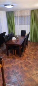a dining room with a wooden table and black chairs at Rapsodia Muntilor in Stațiunea Climaterică Sâmbăta