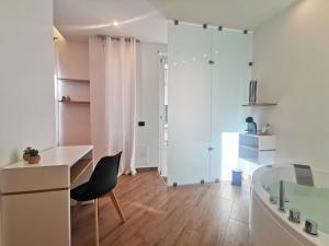 a bathroom with a desk and a chair and a tub at Maqueda Mood in Palermo
