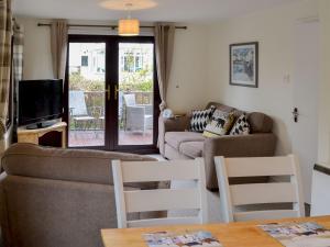 a living room with a couch and a tv at Josnor Chalet in Benllech