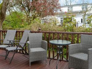 a patio with chairs and a table on a deck at Josnor Chalet in Benllech
