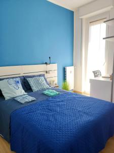 een blauwe slaapkamer met een groot bed met blauwe lakens bij Joy Home 31 in Milaan