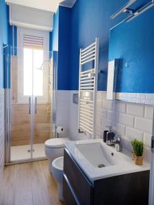 een badkamer met blauwe muren, een toilet en een wastafel bij Joy Home 31 in Milaan