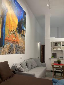 a living room with a couch and a painting on the wall at Golondrinas de Malaga "Apartamentos con mucho Arte" y terraza solarium en coliving in Málaga