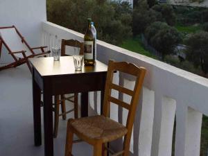 a bottle of wine sitting on a table with chairs at PanoramaKamil in Kamilari