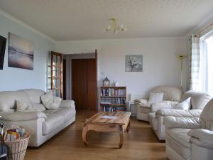 a living room with white couches and a coffee table at Fair View in Lairg