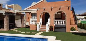 dom z basenem przed nim w obiekcie Villa Preciosa Piscina Climatizada w mieście Mazarrón